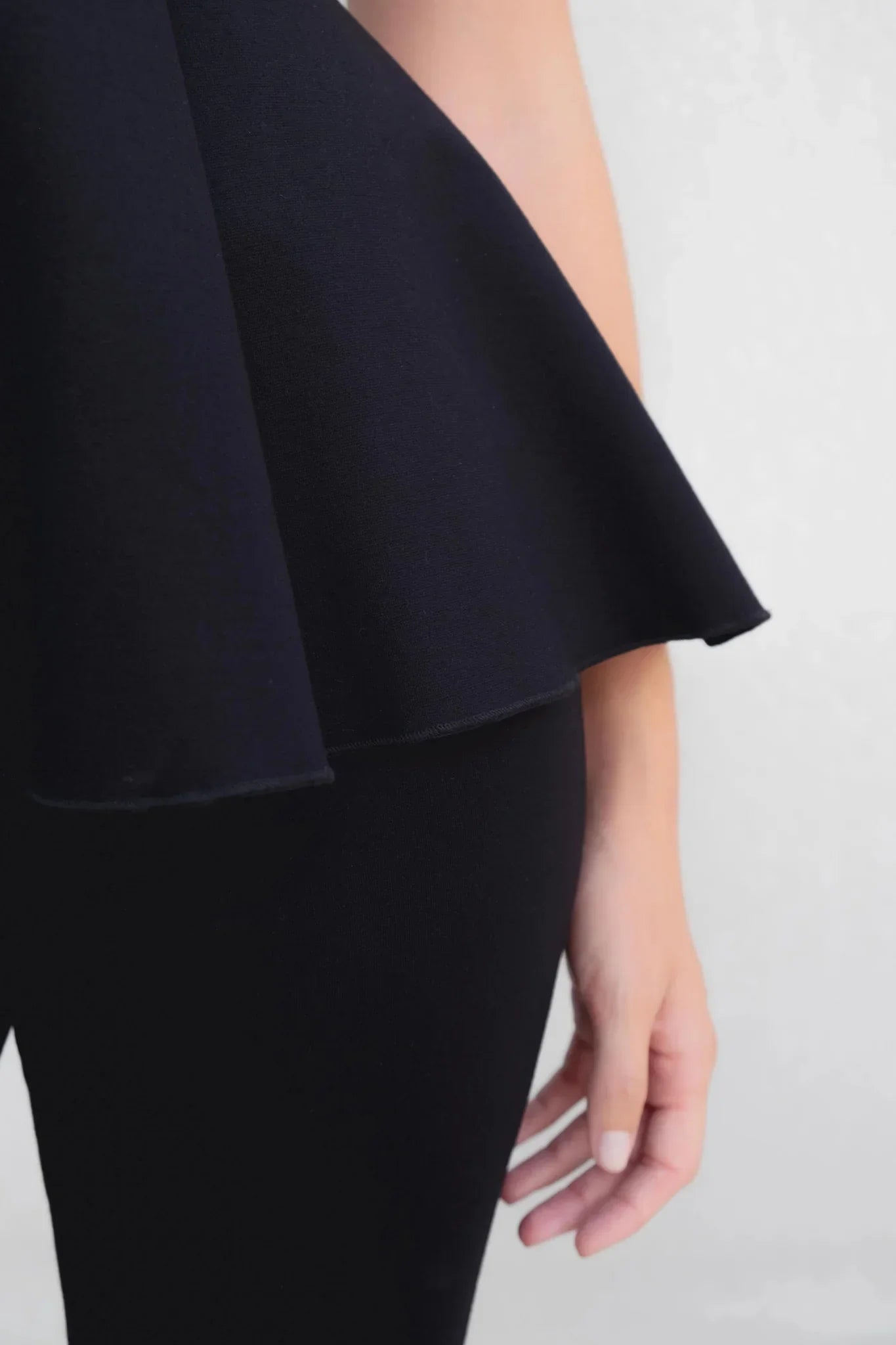 Top noir extensible à encolure ronde avec peplum et manches courtes évasées