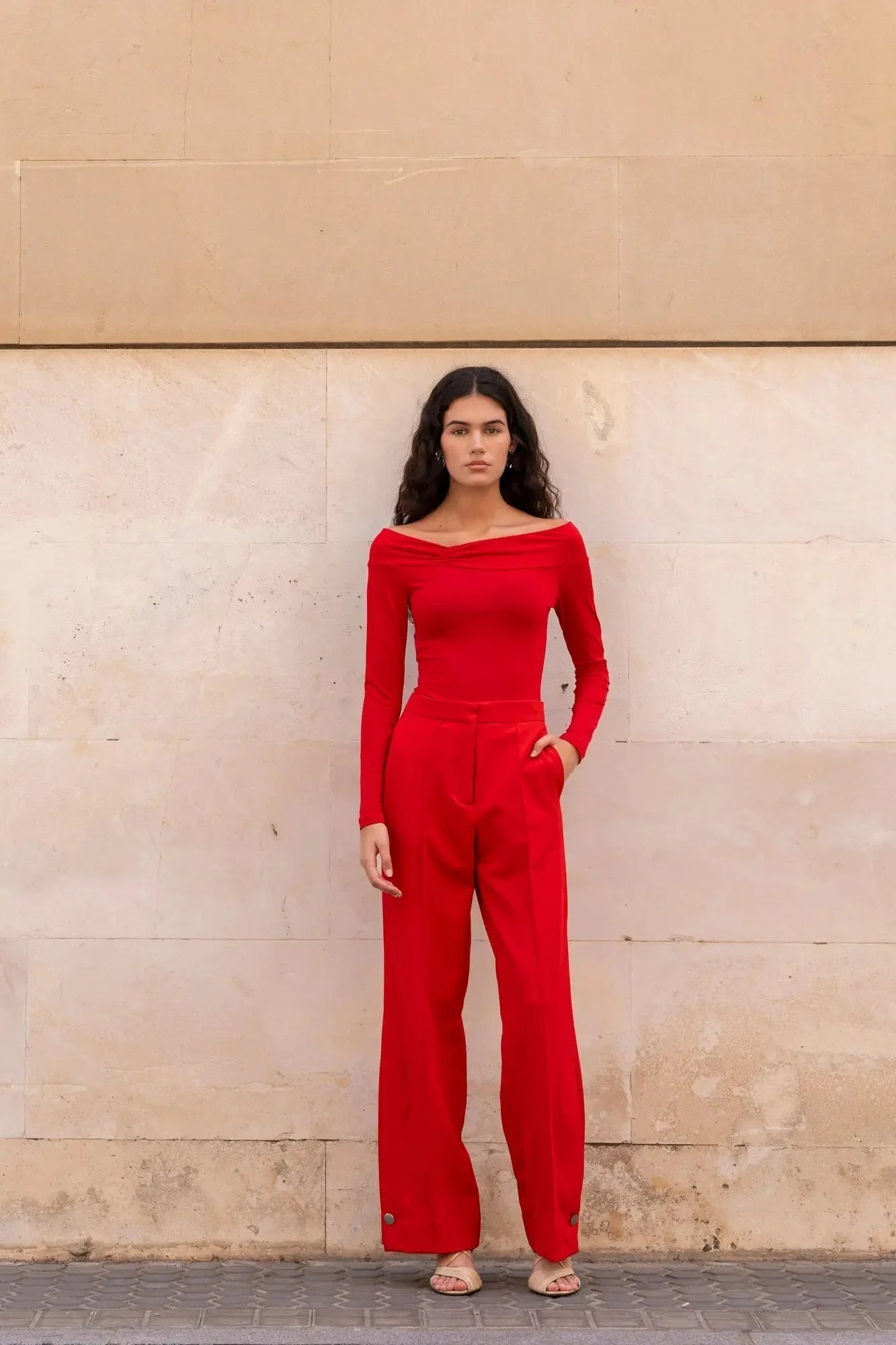 Image d’une femme portant un body rouge à épaules dénudées manches longues
