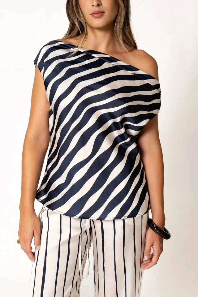 Femme portant un haut satiné à rayures bleu marine et pantalon assorti, style élégant