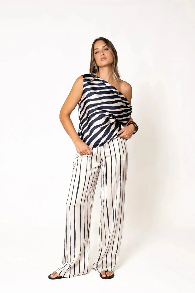 Femme portant un haut satiné à rayures bleu marine et pantalon large rayures bleu