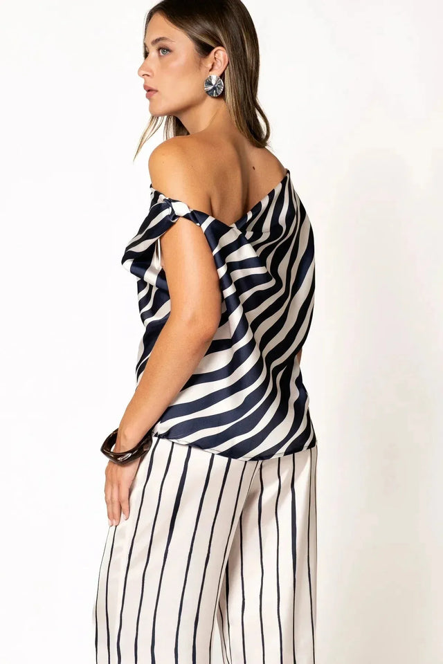 Femme portant un top satiné à rayures bleu marine et pantalon assorti