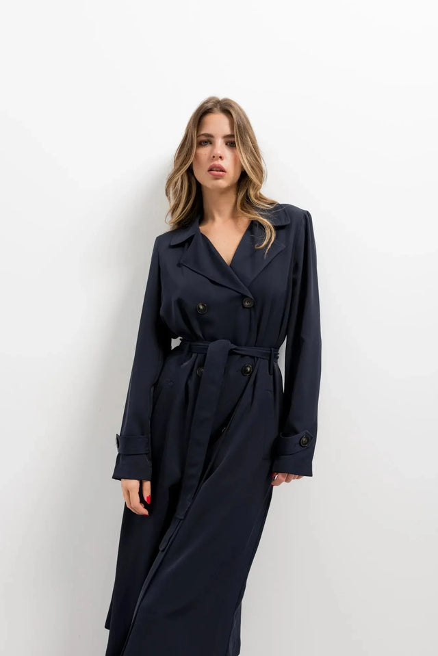Modèle portant un trench coat femme ample long ceinturé élégant avec poches pratiques, affichant un look moderne.