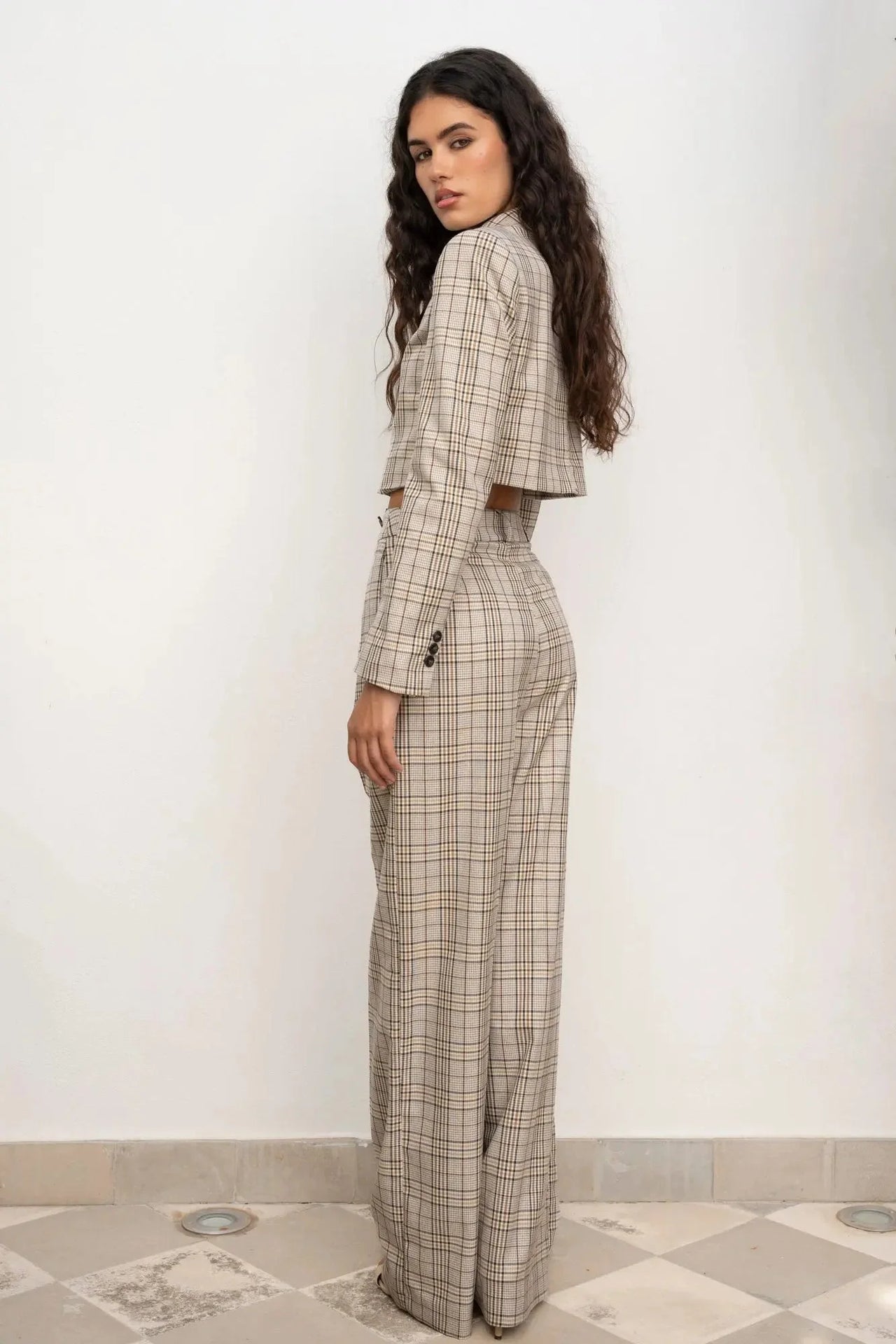 Profil d'une femme portant la Veste Courte Femme à Carreaux Chic – Style Moderne, mettant en avant la coupe cintrée.