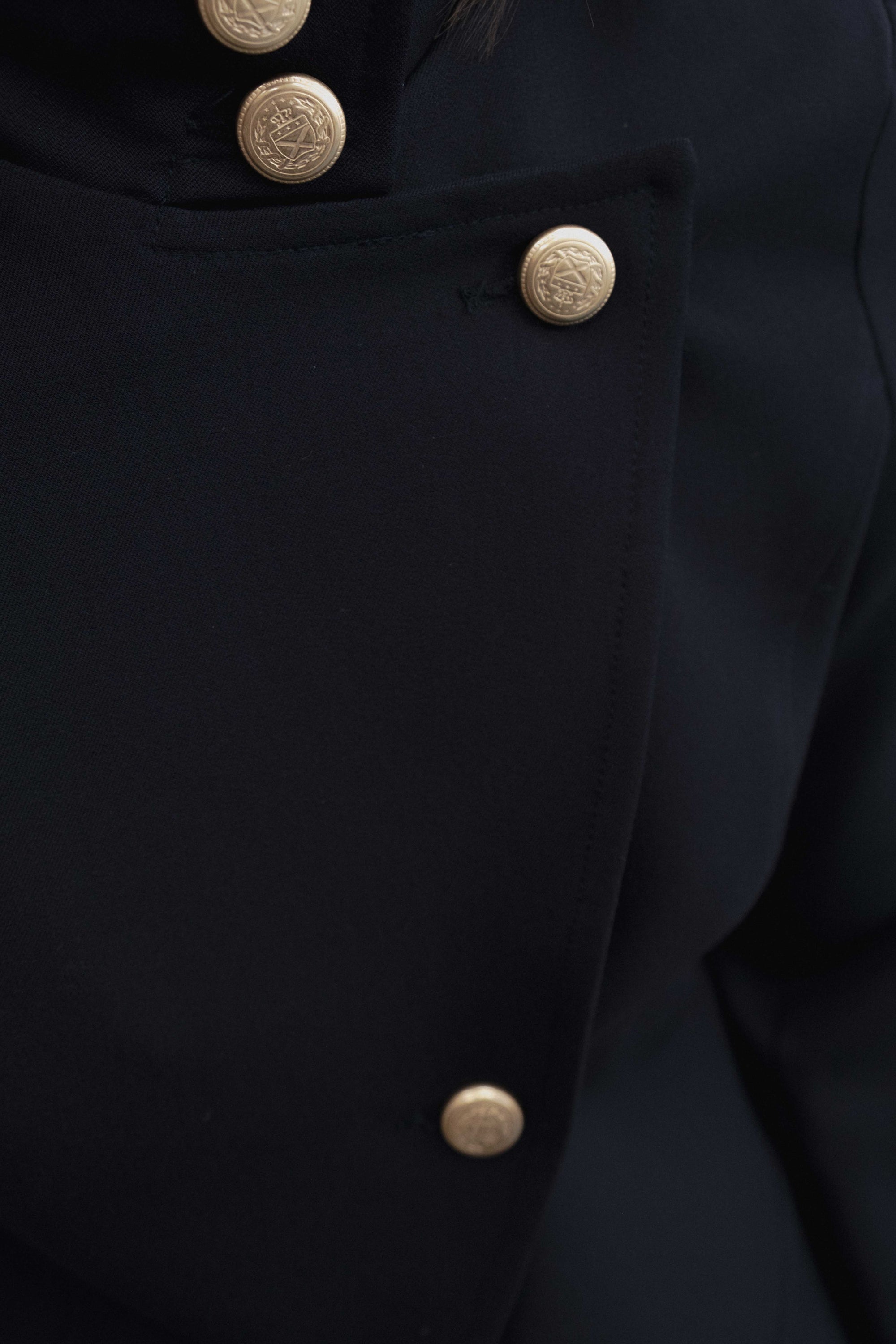 gros plan boutons dorés sur veste marine