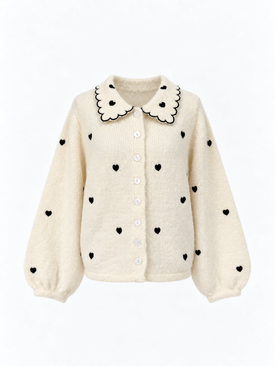 Veste en maille à col et cœurs brodés écrue présentée de face.