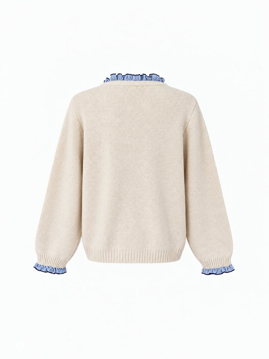 Veste en maille boutonnée à volants écrue à volants bleus, présentée de dos.