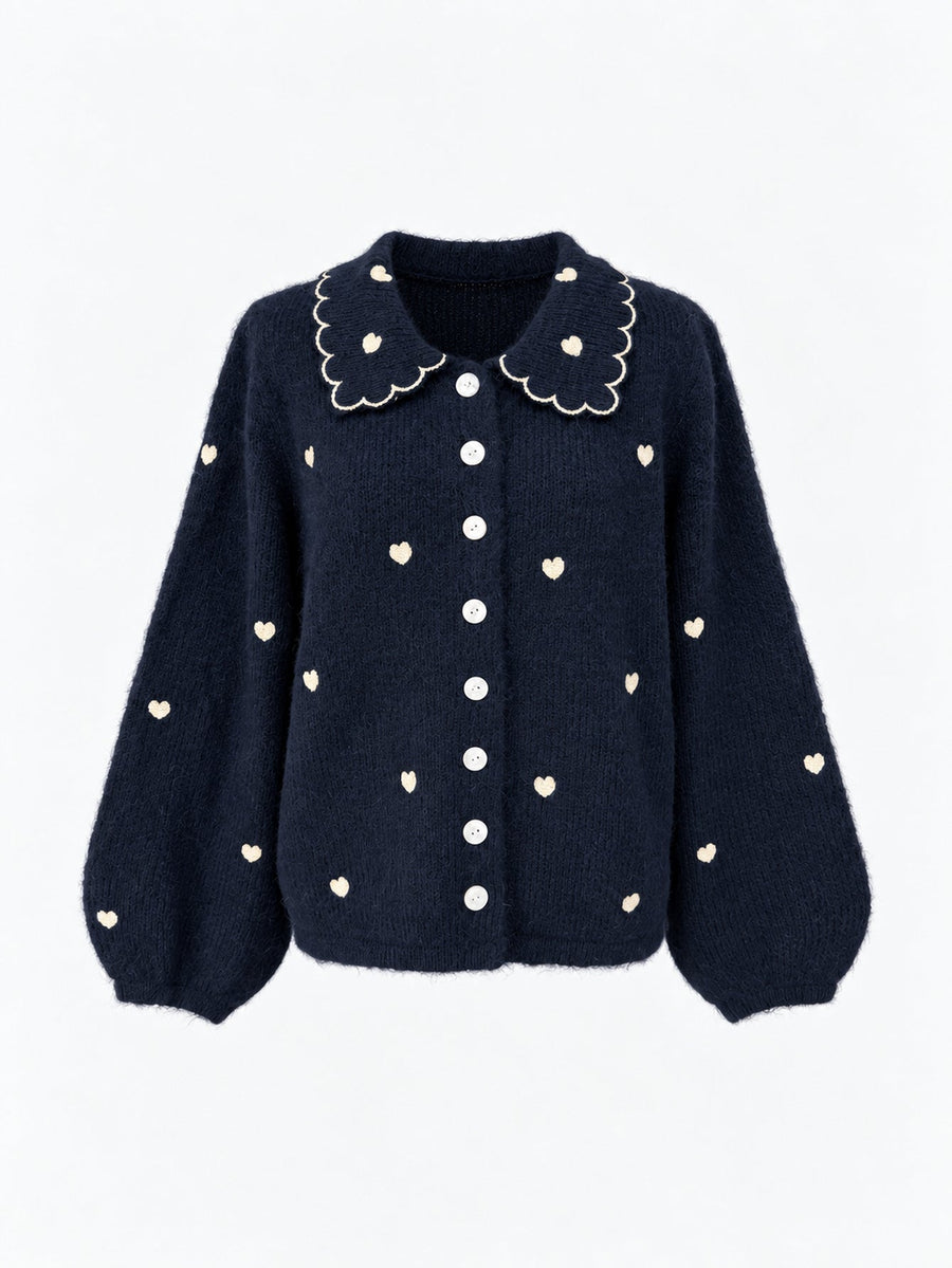 Veste en maille à col et cœurs brodés bleu nuit présentée de face.