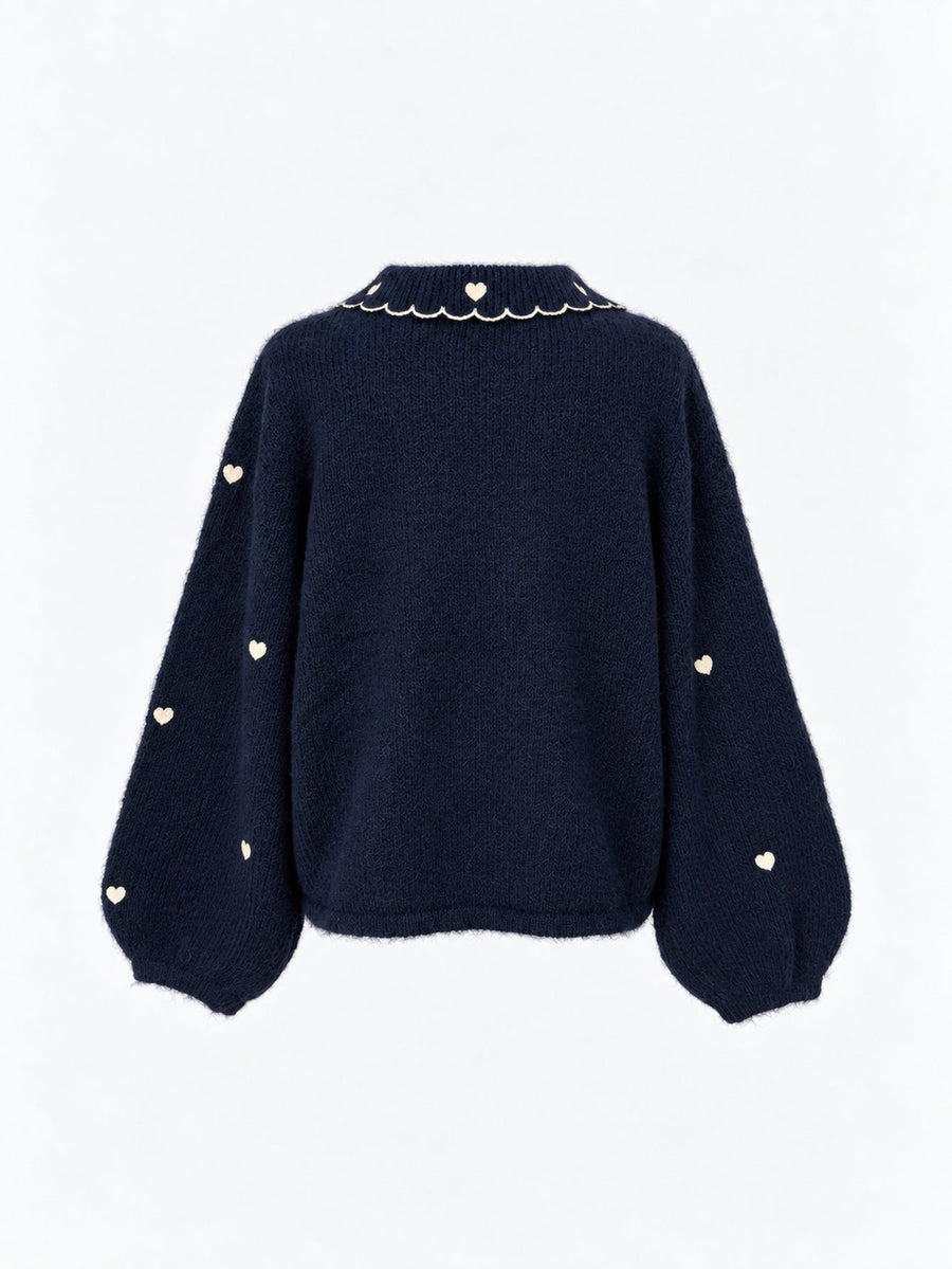 Veste en maille à col et cœurs brodés bleu nuit présentée de dos.