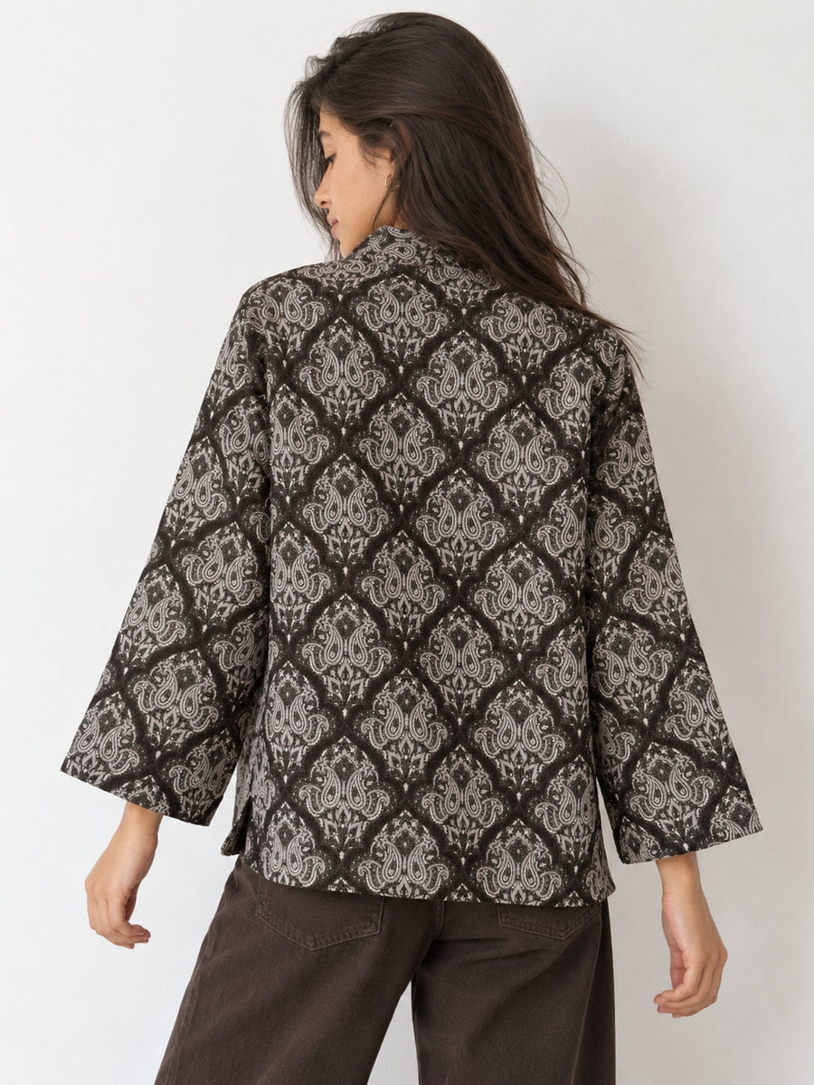 Veste texturée marron pour femme portée de dos.